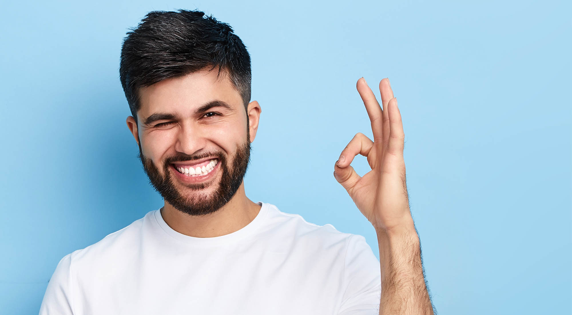 happy cheerful bearded man winking his eye and showing ok sign