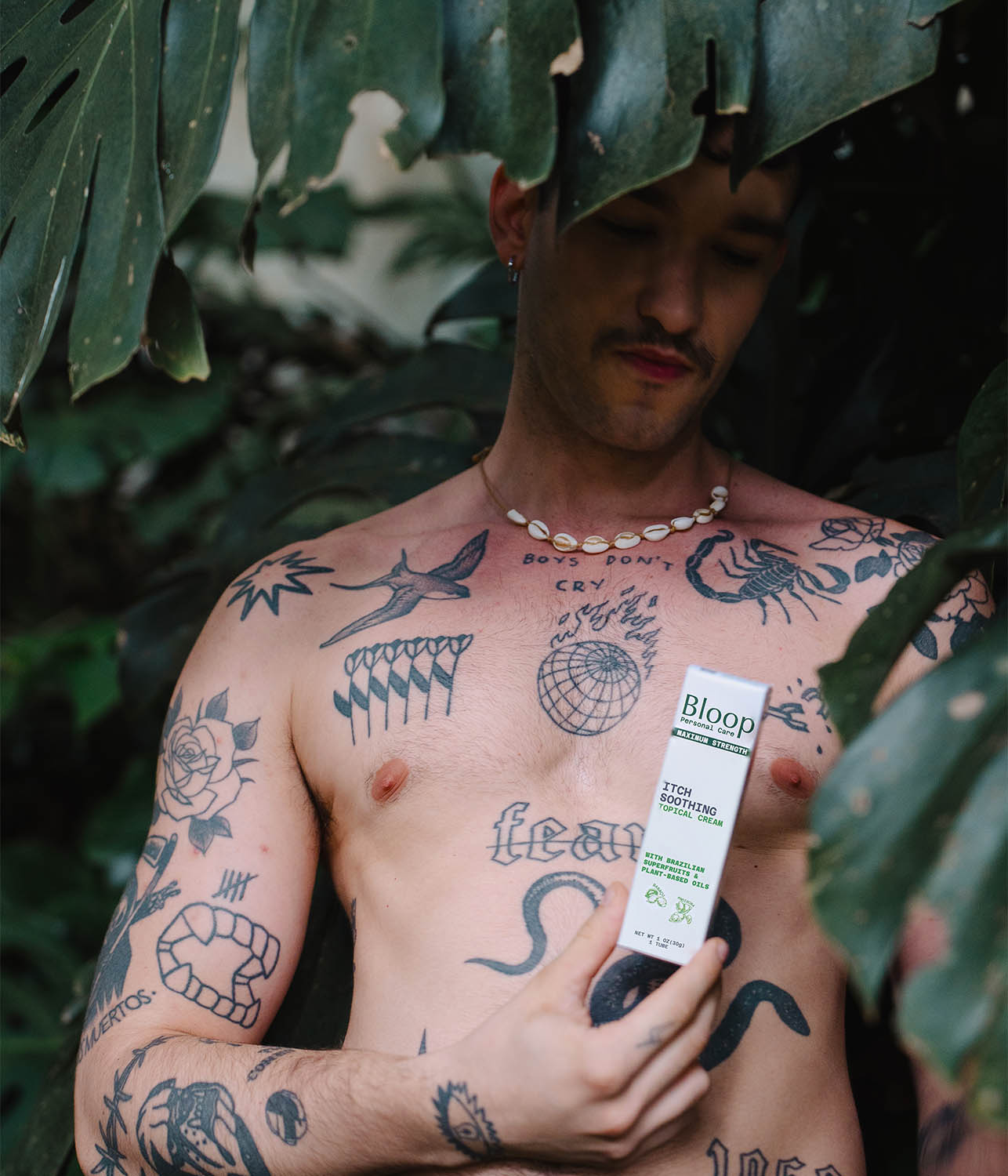 bloop male model holding bloop itch standing under tree